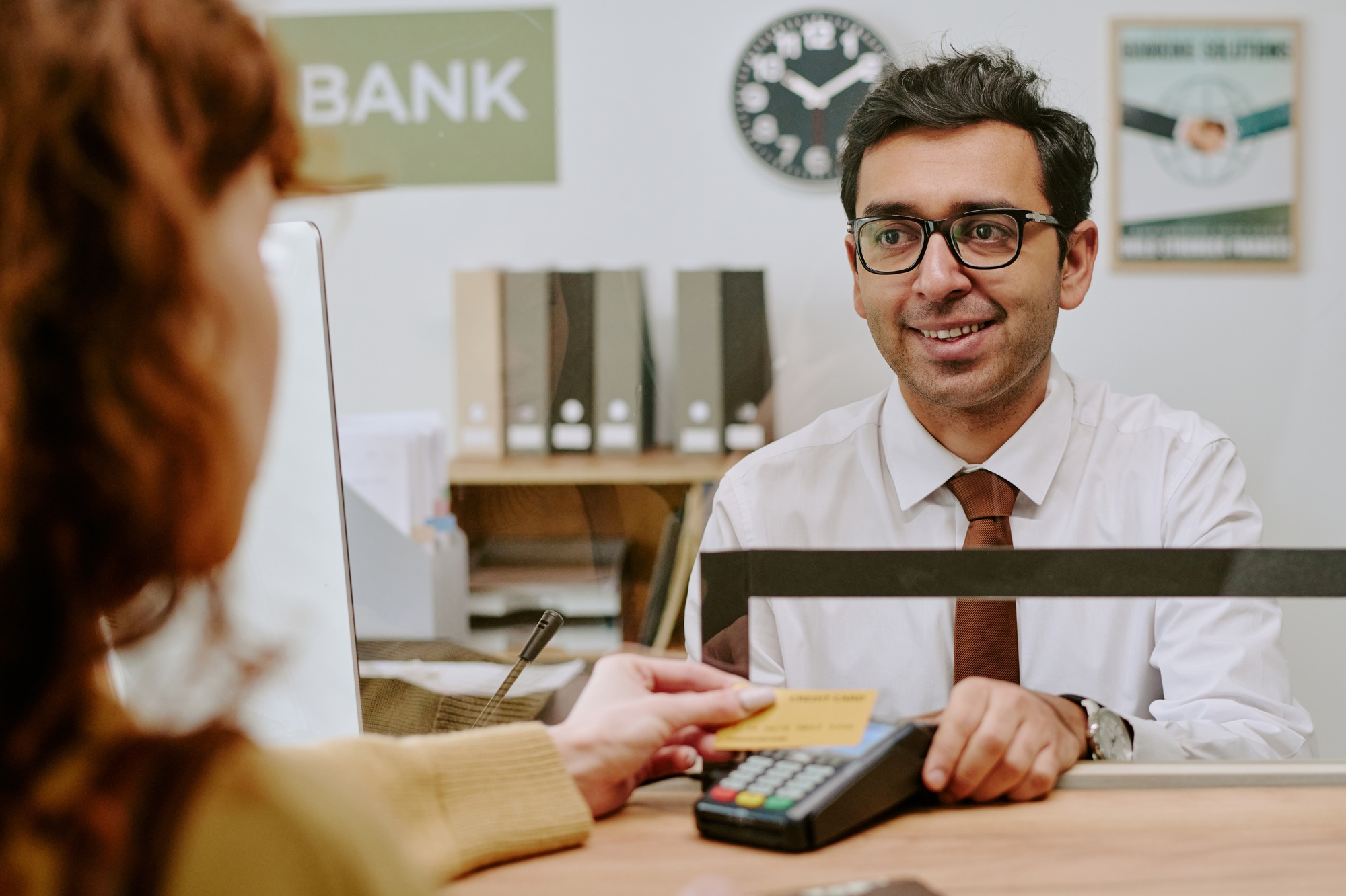 Smiling Bank Teller Assisting Customer at Counter